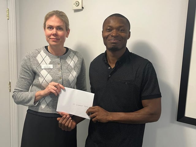 Registered Nurse Emmanuel accepts the £100 voucher presented by General Manager Elina House
