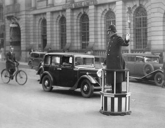 A policeman directs the traffic from a platform. Photograph. Northampton, England. Around 1930. (Photo by Imagno/Getty Images)