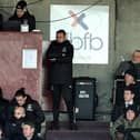 Jon Brady watches on from the back of the stand at Sixfields.