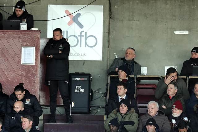 Jon Brady watches on from the back of the stand at Sixfields.