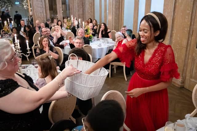 Lorraine Lewis picking a winning raffle ticket