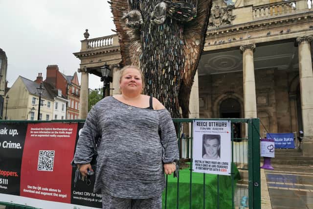 Charlotte Marshall next to a picture of her son Reece and The Knife Angel in Northampton town centre