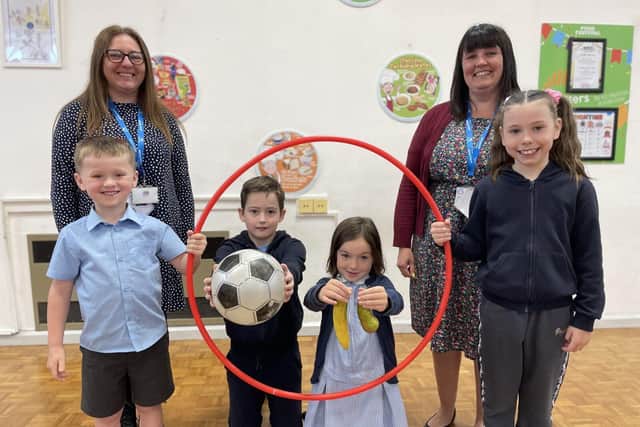 Teachers Amy Hoye and Tara Parker and pupils celebrate their Heathly Schools Award