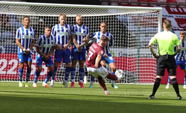 Sam Hoskins picks out the top corner with a fantastic free-kick in the first half of Saturday's League One game between Wigan and Northampton. Picture: Pete Norton.