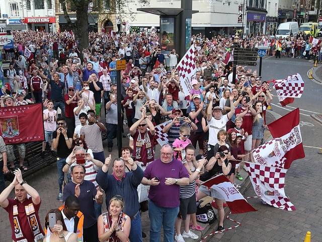 2016:  Northampton Town fans celebrate as they welcome the team as they enter the market sq during the Northampton Town Sky Bet League Two Winners Bus Parade on May 8, 2016 in Northampton, England.  (Photo by Pete Norton/Getty Images)
