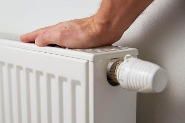 A person putting their hand on the top of a radiator