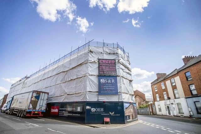 The site had looked like this for months before the scaffolding and wrap were removed