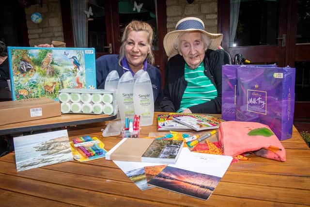 DWSM - 1 - A staff member and resident with the care package donated by David Wilson Homes