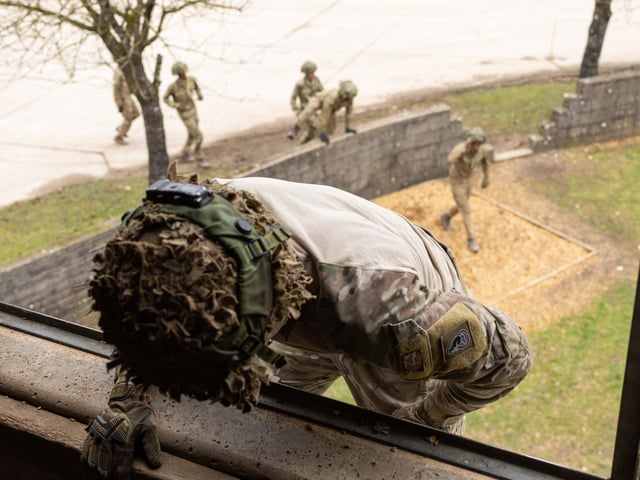 A soldier from 2nd Battalion The Royal Anglian Regiment scales the external ladder to enter a room whilst soldiers below climb the 4ft wall during their confidence course in Copehill Down. This is part of the Regiment's  build up training ahead of their deployment onto Exercise Wessex Storm.