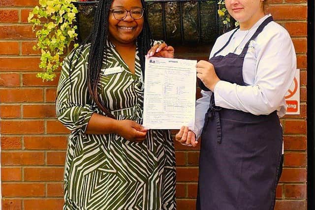 Home Manager, Marvellous Bindura with Head Chef, Sharntelle, holding the EHO inspection report.