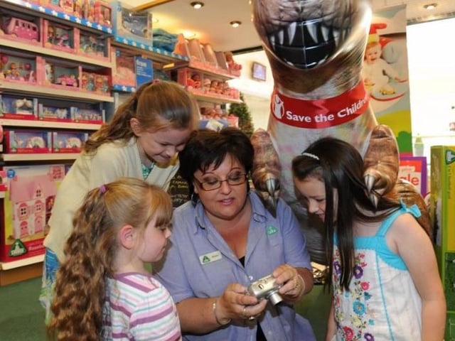 6ft Inflatable Dinosaur raises money for Save the Children in the Early learning centre Peacock Place. In this photograph left to right Becca Leathersich (7) Beth Leathersich (5) Sharon Birney (Store manager) and Ellen Doyle (7)