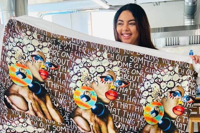 Emily Andrews pictured holding up one of her textile designs.