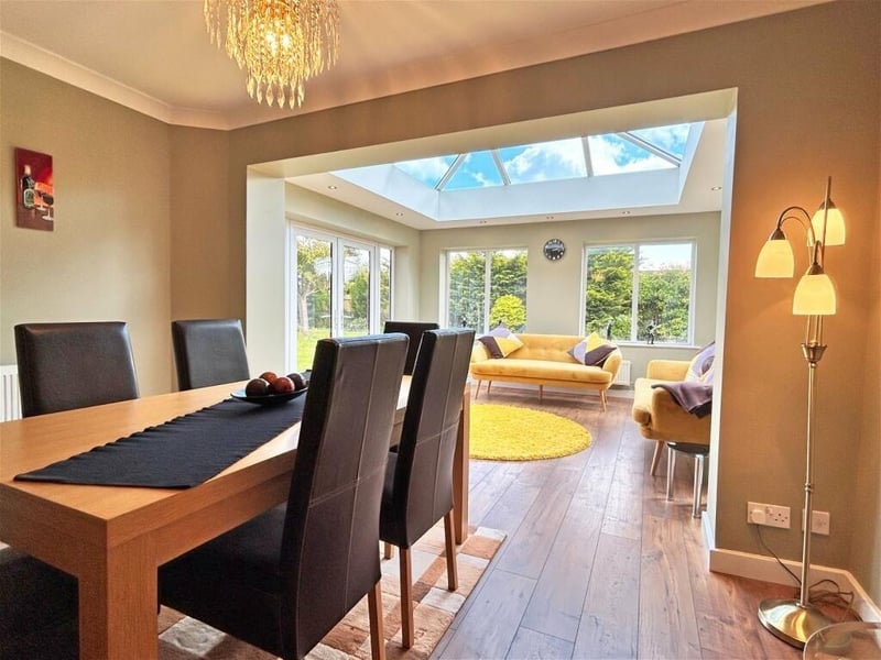 A stunning dining room leads to a large reception room with a vaulted skylight ushering in light