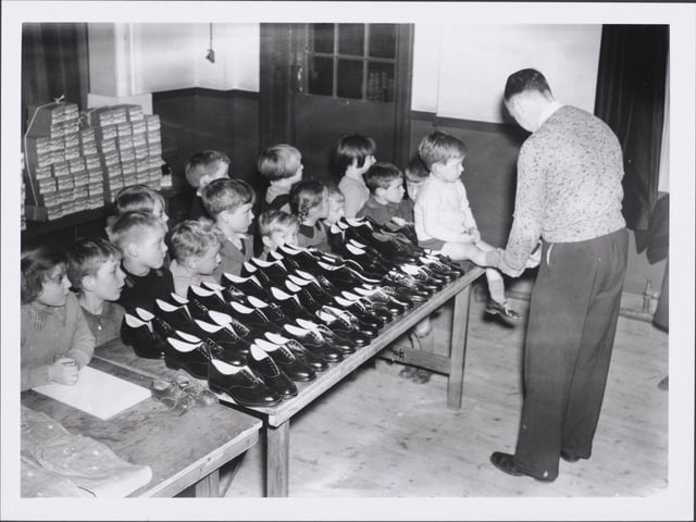 Free Shoes for the Evacuees, Evacuees being fitted with shoes donated by a local brick manufacturing firm near Northampton. (Photo by Hulton Archive/Getty Images)