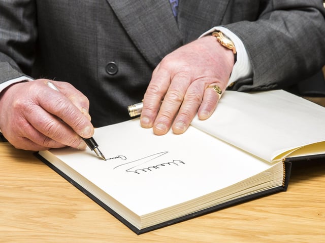 Charles signs a visitors' book on his most recent visit to Northampton, to the Tricker's shoe factory on January 28, 2019