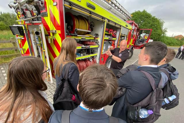 Northants secondary school students being given a tour of a fire engine by Northants Fire and Rescue