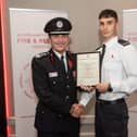 Acting Chief Fire Officer Simon Tuhill presents firefighter Alfie Pendred with his commendation