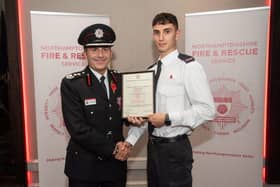 Acting Chief Fire Officer Simon Tuhill presents firefighter Alfie Pendred with his commendation
