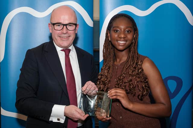 Sarah accepting her award from Sir Jon Coles