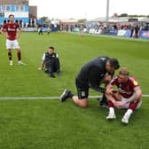 Dejected Cobblers players sit on the pitch after their 3-1 win at Barrow on the final day of the 2021/22 season. The victory wasn't enough as Bristol Rovers won 7-0 to pip them to promotion on goals scored (Photo by Pete Norton/Getty Images)
