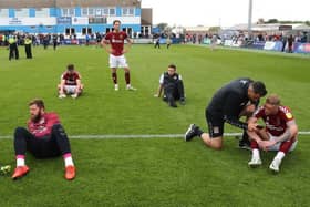 Dejected Cobblers players sit on the pitch after their 3-1 win at Barrow on the final day of the 2021/22 season. The victory wasn't enough as Bristol Rovers won 7-0 to pip them to promotion on goals scored (Photo by Pete Norton/Getty Images)