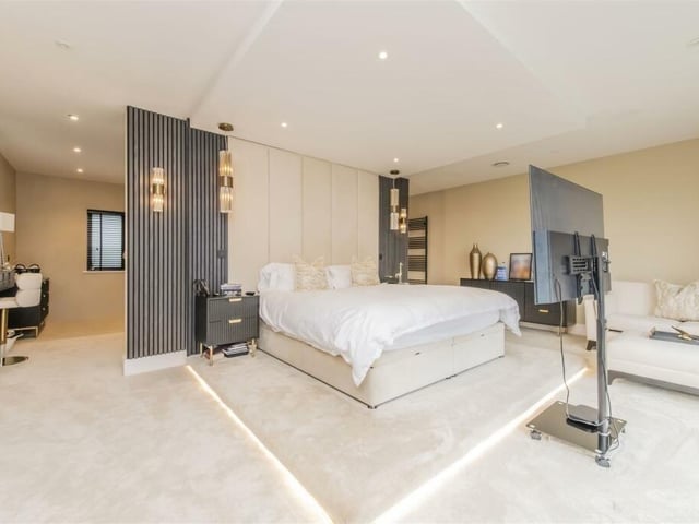 A master bedroom has enough room for its own seating area and even a mobile television stand