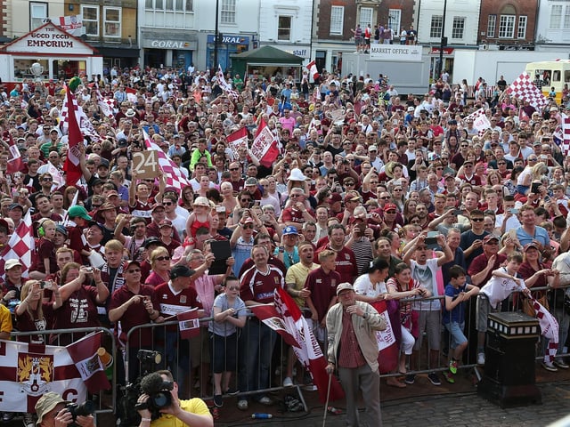 2016: Northampton Town fans celebrate as they welcome the team as they enter the market sq during the Northampton Town Sky Bet League Two  Winners Bus Parade on May 8, 2016 in Northampton, England.  (Photo by Pete Norton/Getty Images)