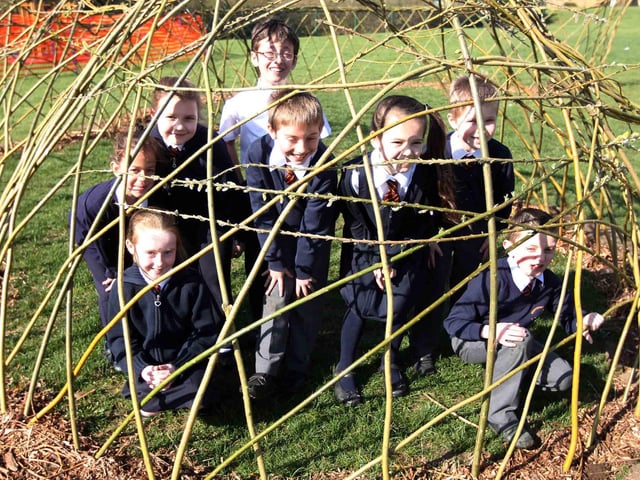 Year three children from Kingthorpe Village Primary School next to a  living willow structure built in the grounds.