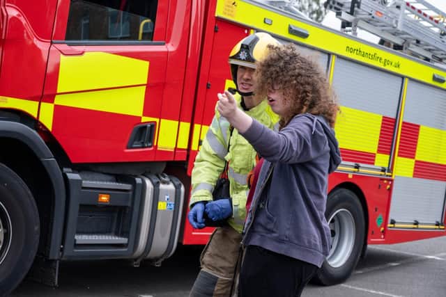 A young person from the GAINN Project talking to a firefighter