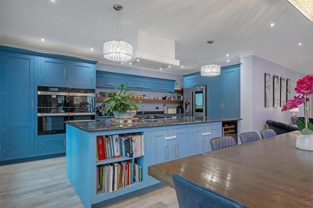 Here is the vibrant blue open plan kitchen-diner and family room.