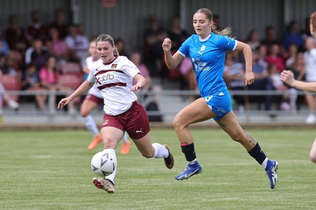 Cobblers' Alex Dicks moves forward with the ball away from Niamh Connor of Peterborough United