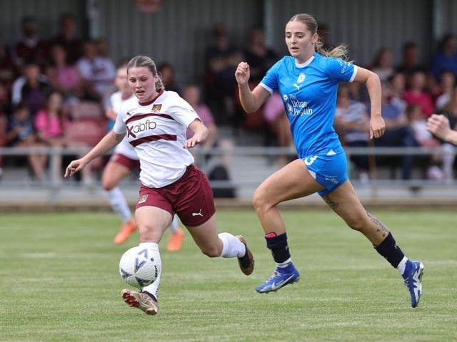 Cobblers' Alex Dicks moves forward with the ball away from Niamh Connor of Peterborough United