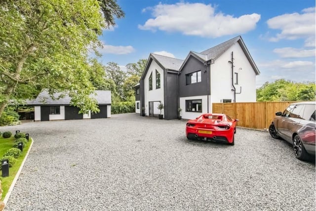 The luxurious driveway boasts room for multiple cars as well as a detached garage