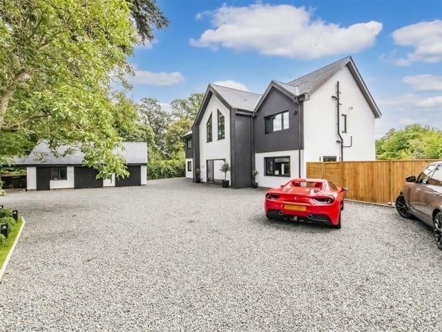 The luxurious driveway boasts room for multiple cars as well as a detached garage