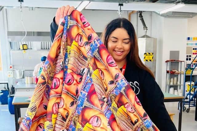 Emily Andrews pictured holding up one of her textile designs.