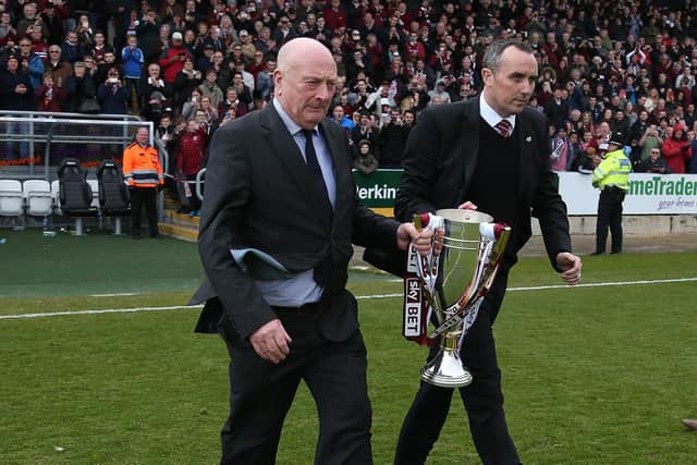 Former manager Graham Carr, who was the last Northampton Town manager to win a championship and current chairman Kelvin Thomas walk out with the Sky Bet League Two champions trophy at the end of the Sky Bet League Two match between Northampton Town and Luton Town at Sixfields Stadium on April 30, 2016 in Northampton, England.  (Photo by Pete Norton/Getty Images)