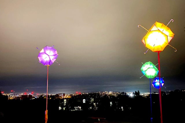 The last leg of the trail features a beautiful 'umbrella carousel' display, set against the backdrop of the twinkling lights of the city itself.