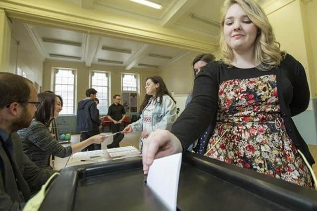 Woman putting a vote in a ballot box