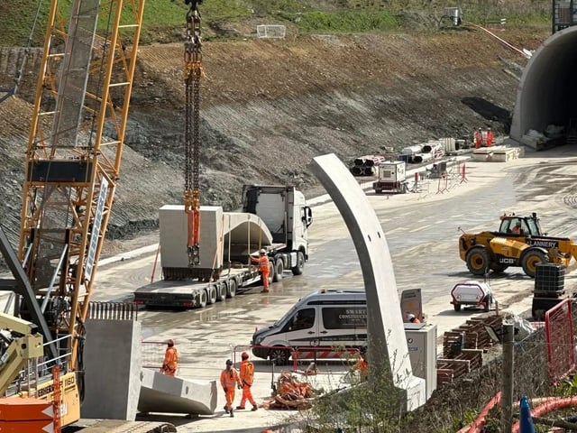 Workers use a crane to lift concrete sections into place at the HS2 Chipping Warden green tunnel site in Northamptonshire.