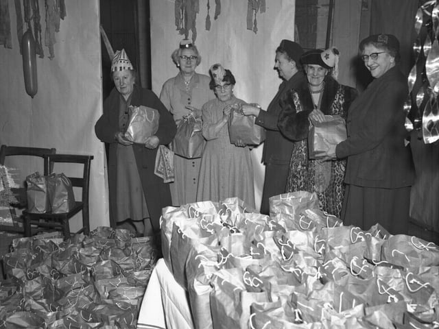 Ladies with Christmas hats and bags of presents