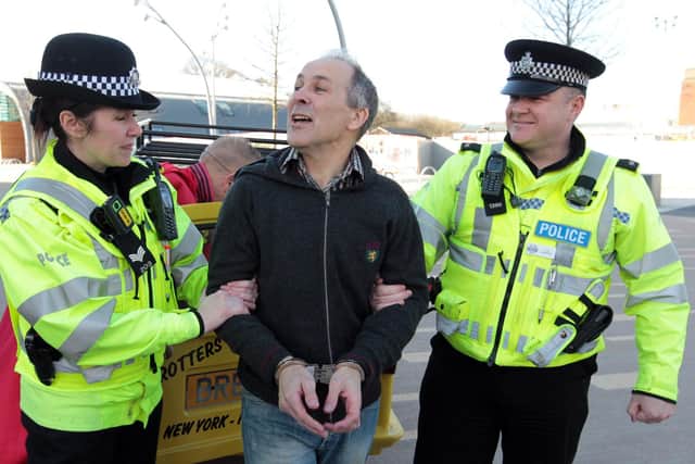 Julie Mead, then a sergeant, handcuffs Corby Council Chief Executive Chris Mallender as part of a stunt with PC Rod MacKenzie back in 2011