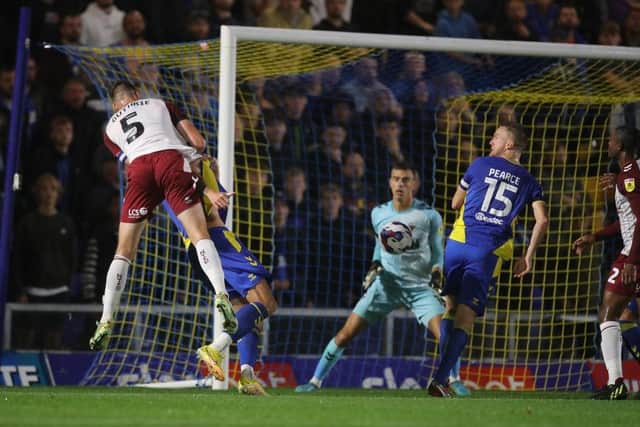 Jon Guthrie rises at the far post to head home the Cobblers opening goal at AFC Wimbledon (Picture: Pete Norton)