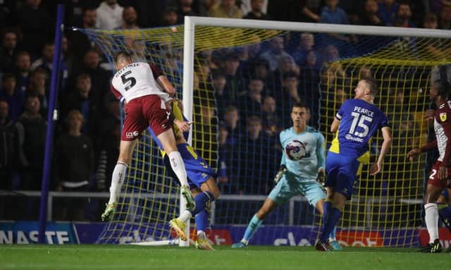 Jon Guthrie rises at the far post to head home the Cobblers opening goal at AFC Wimbledon (Picture: Pete Norton)