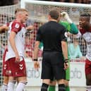 Cobblers players cannot believe referee Martin Woods' decision to award a penalty.