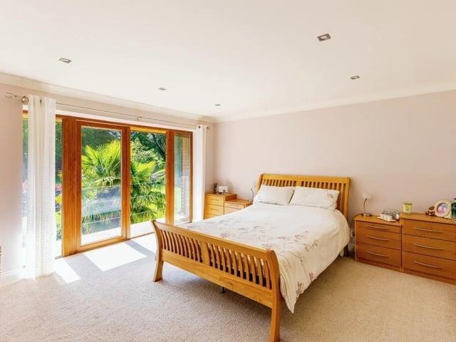 This first floor bedroom features an open balcony with stunning views out onto the back garden