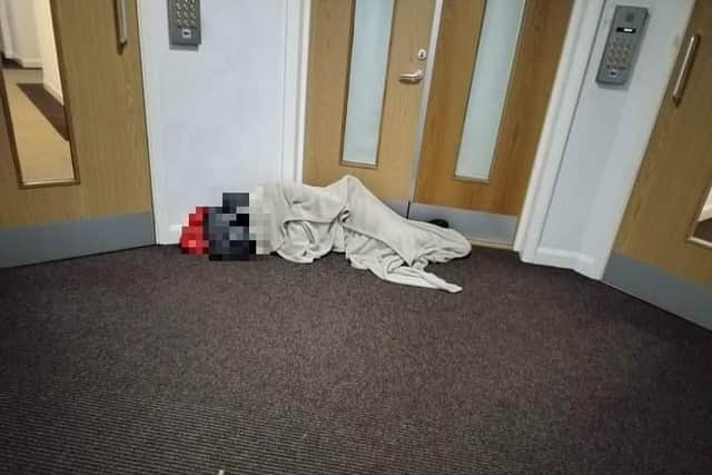 A person sleeping rough in the corridor of the block of flats