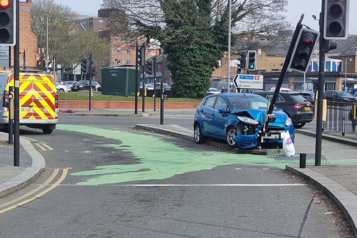 Blauer Ford Fiesta prallt an einem belebten Kreisverkehr in Northampton ...