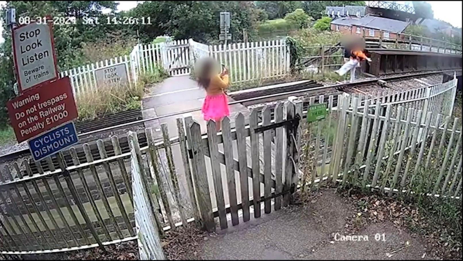 CCTV captures danger couple posing for photo while stood on high-speed railway track