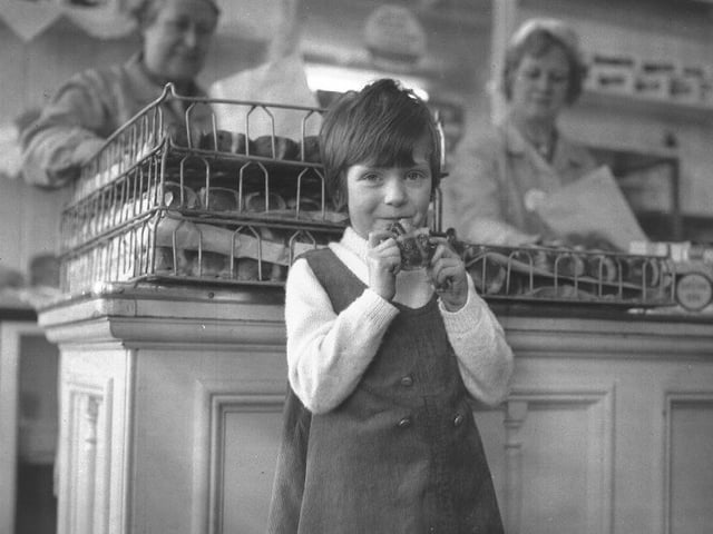 This image shows a bakery in Northampton with a young girl ready to tuck into a hot cross bun. The picture was dated 1969