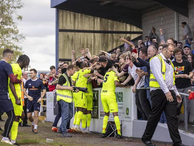 The Brackley Town players and fans celebrate at Chester. Picture by Glenn Alcock